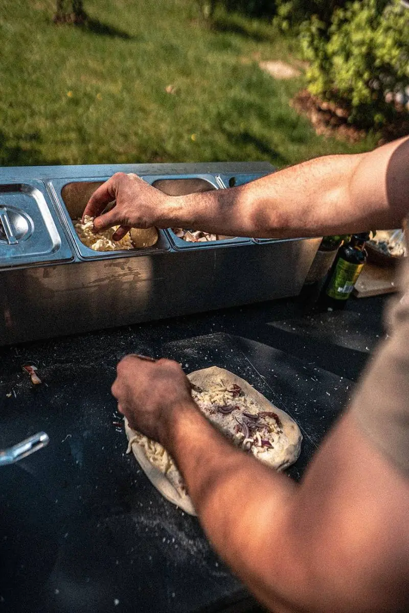 Verse pizza wordt met de hand belegd